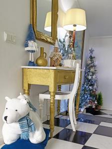 卡马拉-德洛布什ATTIC BAY的坐在桌子旁的白色泰迪熊,手持圣诞树