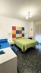 马奥莱B&B Vittoria的酒店客房设有两张床和彩色墙壁。