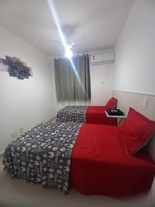 圣若泽-迪里巴马尔Apartamento próximo da praia的一间卧室设有两张床,天花板上拥有灯光