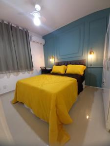 圣若泽-迪里巴马尔Apartamento próximo da praia的一间卧室配有黄色床和黄色枕头