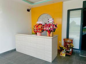 巴地市Ruby Motel Bà Rịa的花店,花瓶插在柜台上