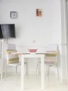 洛斯克里斯蒂亚诺斯Porto Royale的一张带两把椅子的白色桌子和墙上的时钟