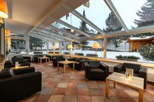 塞尔瓦迪加尔代纳山谷Piccolo Hotel的餐厅配有沙发、桌子和窗户