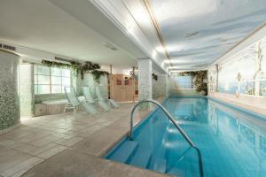 塞尔瓦迪加尔代纳山谷Piccolo Hotel的一个带蓝色椅子的游泳池和一个游泳池