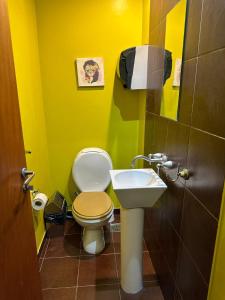 布宜诺斯艾利斯Aparta Hotel的黄色的浴室设有卫生间和水槽
