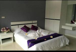 北芭堤雅Pandora House by Mike Group的一间卧室配有一张带紫色枕头的大床