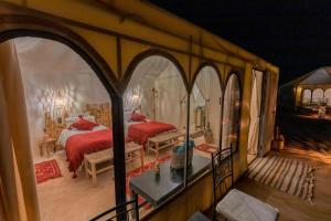 梅尔祖卡Desert Luxury Camp Experience的一间带两张床的卧室,位于带拱门的房间