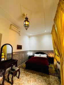 乌季达Dar Al Fassia的一间卧室配有一张床、镜子和吊灯