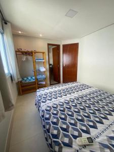 塞古罗港Flat Beira Mar Porto Segur的一间卧室配有一张带蓝色和白色棉被的床