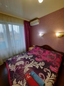 哈尔科夫Квартира возле Радмир ул.Чернивецкая 5в的一间卧室配有一张带紫色和白色毯子的床