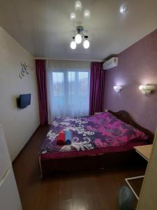 哈尔科夫Квартира возле Радмир ул.Чернивецкая 5в的一间卧室配有一张带紫色棉被的床