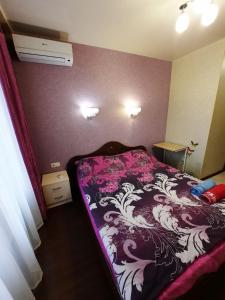 哈尔科夫Квартира возле Радмир ул.Чернивецкая 5в的一间卧室配有一张带紫色和白色毯子的床