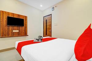 海得拉巴OYO Hotel Night Eye的卧室配有一张带红色毯子的白色床