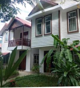 西哈努克Manoha Villa的白色的房子,设有门廊和阳台