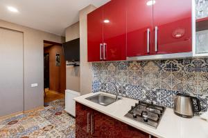 第比利斯Apartment on Borbalo 16的一间带红色橱柜和水槽的厨房