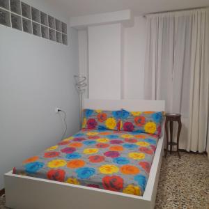 威尼斯Veneziacentopercento Apartments & Rooms的一间卧室配有一张带花卉棉被的床