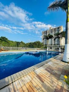 圣若泽-迪里巴马尔House praia的一座棕榈树和建筑的游泳池