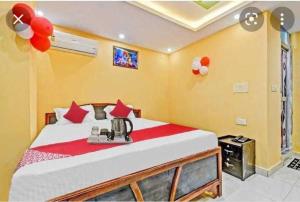 巴特那OYO Hotel Swarna Palace的一间卧室配有一张带红色枕头的大床