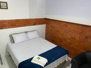 里约布兰科Pousada Amazônia的砖墙客房内的小床