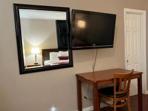 北山北山家乡旅馆的配有桌子、镜子和电视的房间