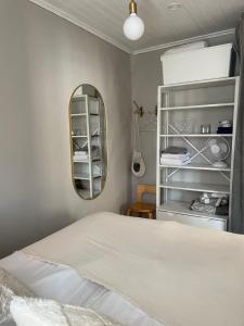 帕尔加斯Small house central Parainen by Archipelago Trail的卧室配有白色的床和镜子