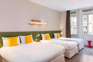 图卢兹Matabi Hotel Toulouse Gare by HappyCulture的配有黄色枕头的酒店客房的两张床