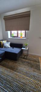 New SouthgateLovely 2 bedroom Flat with Free Parking的客厅设有蓝色的沙发和窗户。
