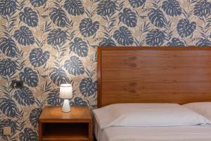毕博纳的码头Hotel Riva Etrusca的一间卧室配有蓝色和白色壁纸的床
