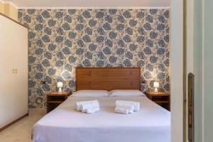 毕博纳的码头Hotel Riva Etrusca的一间卧室配有一张床,上面有两条毛巾