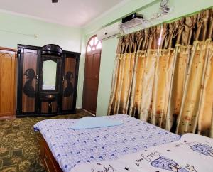 巴拉特布尔Ojas Home Bharatpur的一间卧室配有两张床和镜子