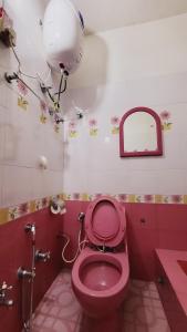 巴拉特布尔Ojas Home Bharatpur的浴室设有粉红色的卫生间和镜子