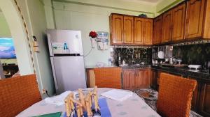 巴拉特布尔Ojas Home Bharatpur的厨房配有桌子和白色冰箱。