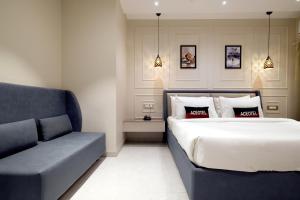 印多尔Aceotel Select Tulsi Vijay Nagar的一间卧室配有一张床和一张沙发