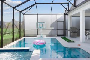 奥兰多Villatel Orlando Resort的一座玻璃墙房子内的游泳池
