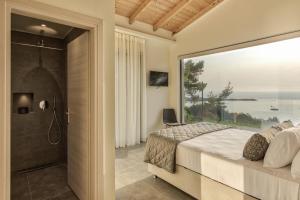 瓦西里科斯Luxury Villa Mon I Vassilikos的一间卧室设有一张床和一个大型玻璃窗
