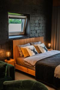 MustkalniBriežu Kūts的卧室配有带枕头的床铺和窗户。
