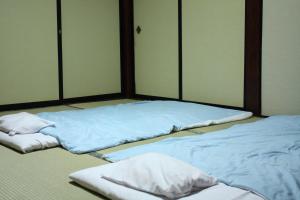 鹤冈市多闻馆酒店的配有蓝色床单的客房内的两张床