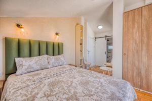 蒂瓦特Miro guesthouse的一间卧室配有一张大床和绿色床头板