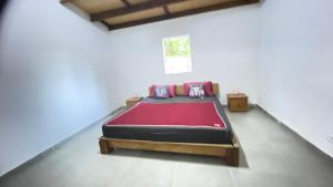 穆龙达瓦Harena Villa的一间卧室配有一张带红色毯子的床