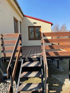 昆塞斯波德安德莱基尼科姆Ubytování pod Stolovou的房屋前的木甲板上设有2个长椅