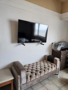 马瑙斯Tropical Executive Hotel的客厅设有一张沙发,配有平面电视。