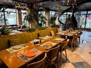 布克维Ribas Karpaty的餐厅设有木桌和椅子,并拥有圣诞树