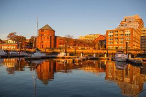 波士顿Sea Pearl Boston Yacht的水面上建有建筑物和船只的城市