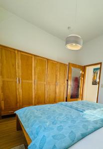 什未林Attraktive Wohnung im grünen Hinterhof的一间卧室配有木制橱柜和一张蓝色的床。
