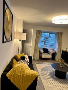 阿克灵顿Mo Apartment的客厅配有黑色沙发和黄色毯子