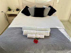 内坦亚Beachfront Studio, fully equipped的一张带两条毛巾的床,上面有玫瑰