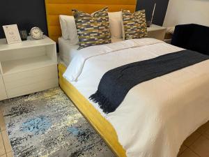 肯普顿帕克Aneiwa airport lodge的一间卧室配有一张大床和木制床头板