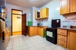 内罗毕MANI HOMES的厨房配有木制橱柜和黑炉。