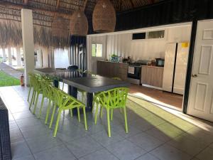 AcajutlaOcean fronthouse in Salinitas的一间厨房,内设一张桌子和绿色椅子