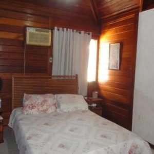 马里卡Cakau House - espaço amplo e aconchegante的木制客房内的一间卧室,配有一张床